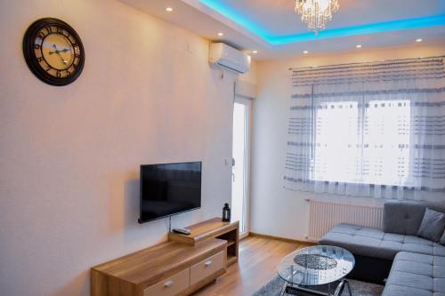 a living room with a couch and a clock on the wall at Apartman BLAGOJEVIĆ in Banja Koviljača