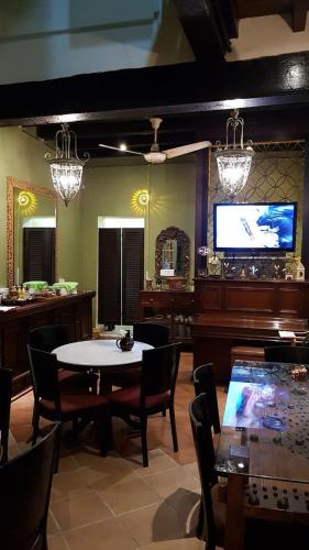 una sala da pranzo con tavolo e TV a schermo piatto di Cintra House a George Town