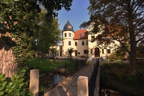 a building with a fence in front of it at Parkschlößchen in Maasdorf