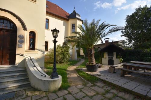 a building with a street light next to a bench at Parkschlößchen in Maasdorf