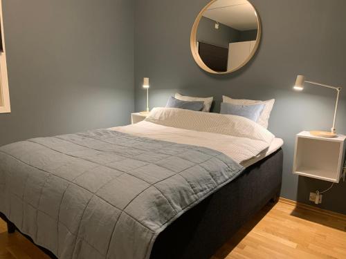1 dormitorio con 1 cama con espejo en la pared en Modern apartment in the Harbour of Jørpeland en Jørpeland