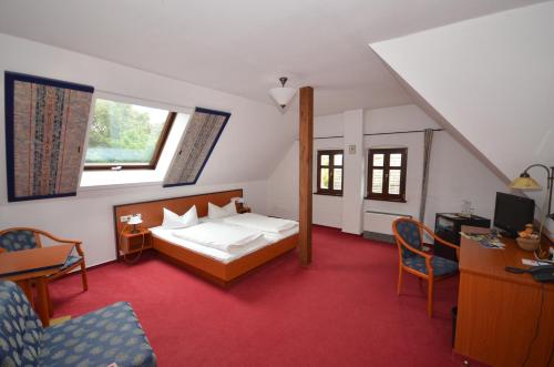 a bedroom with a bed and a desk and chairs at Parkschlößchen in Maasdorf