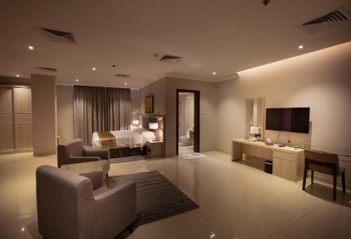 a large living room with a bed and a television at SOMEDAYS Serviced Apartments - Standard in Al Hofuf