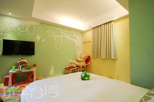 a bedroom with a teddy bear sitting in a chair at Yes Villa in Luodong