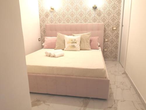 a large bed with pink and white pillows on it at Domus Leone Tre in Naples