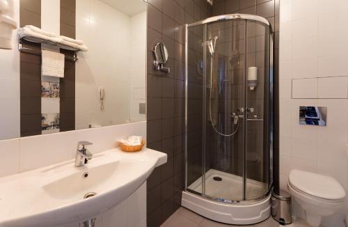 a bathroom with a shower and a sink and a toilet at Hotel Megapolis in Bryansk