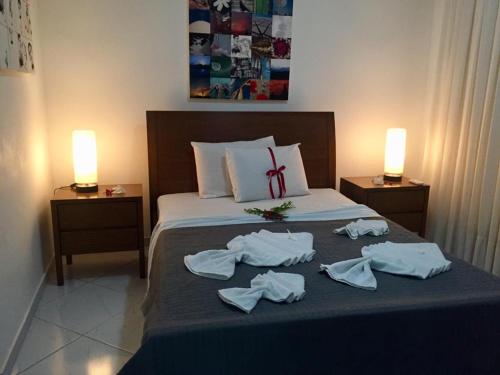 a bedroom with a bed with towels on it at Indulge and Relax Apartment in Pipa