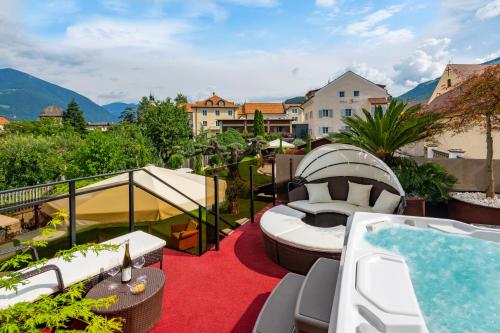 a balcony with a hot tub and a relaxation room at Hotel Traube in Bressanone