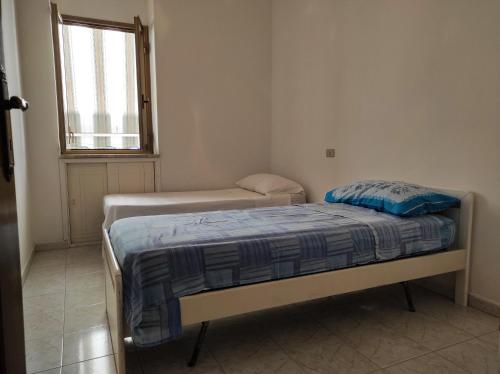 a small bedroom with two beds and a window at Appartamento a pochi passi dal mare in Villapiana