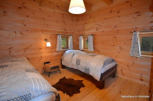 a bedroom with two beds in a log cabin at Naturhaus Innviertel in Holzöster