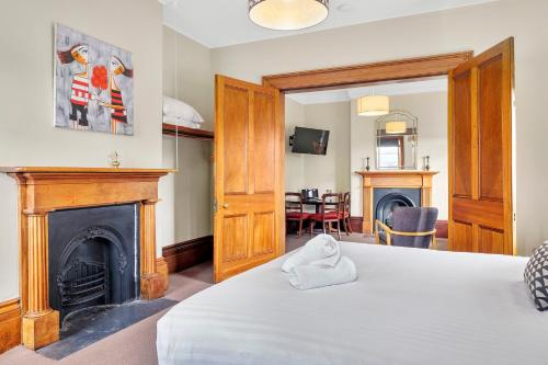 a room with a bed and a fireplace at Cromwell Apartment - 3 Red Doors Battery Point in Hobart