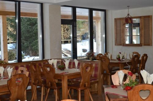 a dining room with tables and chairs and windows at Domeniul Dornei in Vatra Dornei