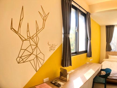 a bedroom with a desk and a deer decal on the wall at A Day in Lukang Homestay in Lugang