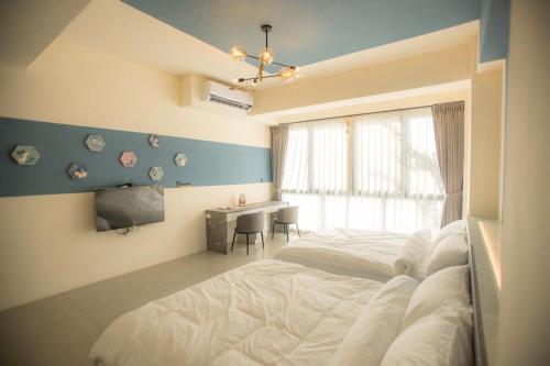 a bedroom with a bed and a desk and a window at A Day in Lukang Homestay in Lugang