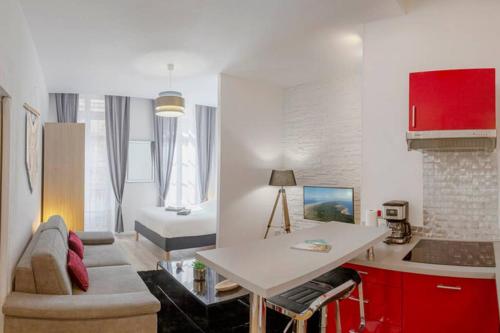 une cuisine et un salon avec une table et un canapé dans l'établissement Logement de charme - Saint Pierre - Cœur historique Bordeaux, à Bordeaux