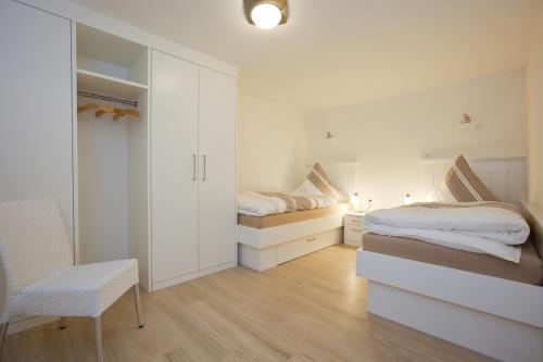 1 Schlafzimmer mit 2 Betten, einem Schreibtisch und einem Stuhl in der Unterkunft Norderneytraum Kampstr. Whg. 3 in Norderney