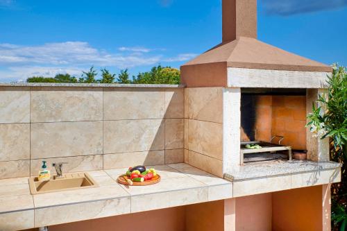 a outdoor kitchen with a pizza oven on a building at Villa Bartona for 8 persons with private Swimmingpool in Pula