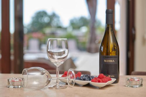 a bottle of wine and a glass and berries on a table at Villa Bartona for 8 persons with private Swimmingpool in Pula