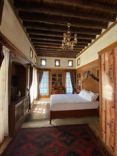 a bedroom with a large bed and a chandelier at Kasr-ı Canan in Halfeti