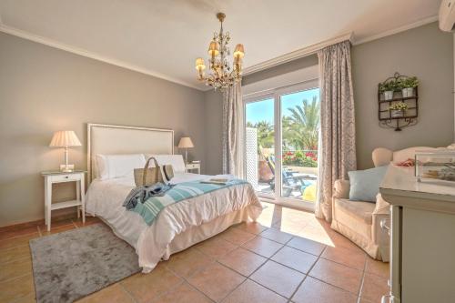 ein Schlafzimmer mit einem Bett, einem Sofa und einem Fenster in der Unterkunft La Buganvilla de Marbella in Marbella