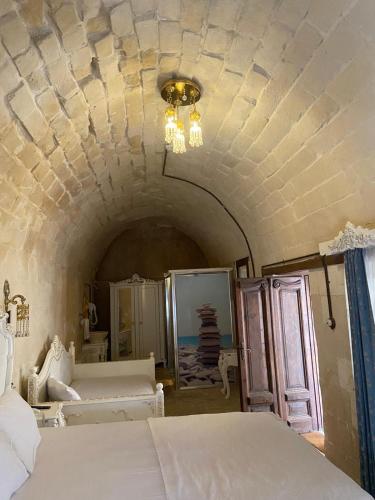 a room with two beds and a ceiling at Kasr-ı Canan in Halfeti