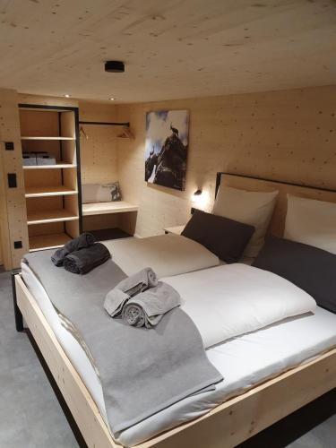 1 dormitorio con 1 cama grande y toallas. en Chaletwohnung Dorfbrunnen en Oy-Mittelberg