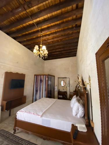 a bedroom with a bed and a chandelier at Kasr-ı Canan in Halfeti
