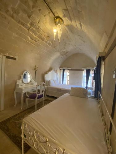 a bedroom with a bed and a desk in a room at Kasr-ı Canan in Halfeti