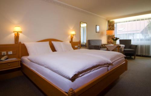 a bedroom with a large bed in a hotel room at Gästehaus Huber - Hotel Garni in Bad Füssing