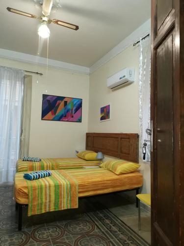 a bedroom with two beds and a ceiling fan at La casa del corso in Aragona