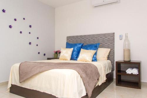 1 dormitorio con 1 cama grande con almohadas azules en CondoHotel 5th Avenue Basic Studio, en Playa del Carmen