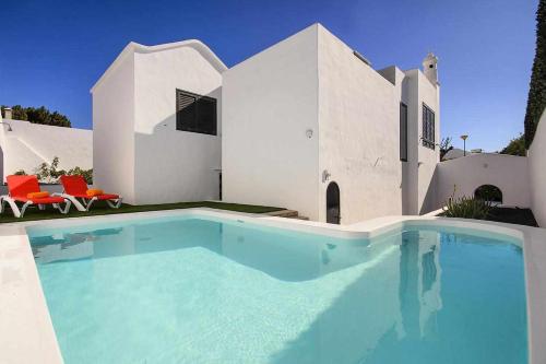 a swimming pool in front of a house at Casa Jardin ideal para familias in Arrecife