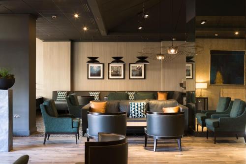 a waiting area with chairs and a table in a restaurant at Crowne Plaza Harrogate by IHG in Harrogate