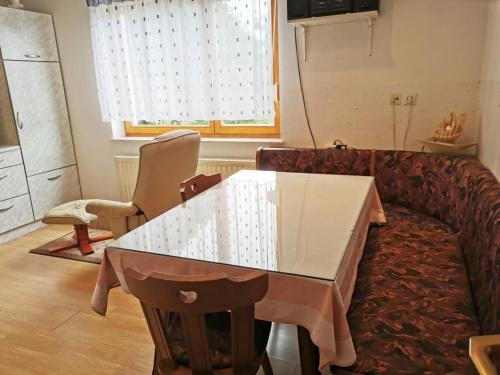 a living room with a table and a couch at Urlaub für die Seele - Erholung Pur in der Natur - Ferienhaus mit Infrarotkabine & RELAX-Raum in Rucmanci