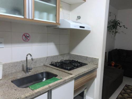 Il comprend une cuisine équipée d'un évier et d'une cuisinière. dans l'établissement Apartamento em Caldas Novas, à Caldas Novas