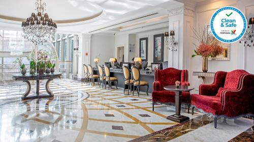 a lobby with red chairs and a barber shop at InterContinental Porto - Palacio das Cardosas, an IHG Hotel in Porto
