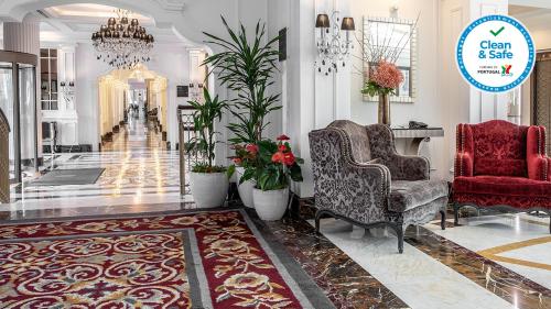a lobby with two chairs and a chandelier at InterContinental Porto - Palacio das Cardosas, an IHG Hotel in Porto
