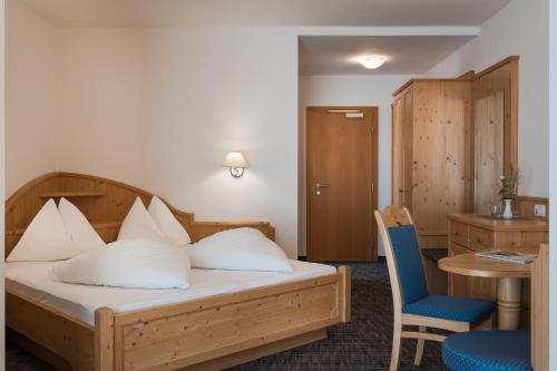 a hotel room with a bed and a table and chairs at Park Hotel Villa Etschland in Plaus