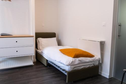a small bedroom with a bed and a dresser at PANACHE - BIKE EN SLEEP HOTEL in La Roche-en-Ardenne