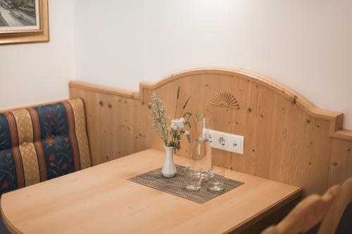 a wooden table with a vase of flowers on it at Park Hotel Villa Etschland in Plaus