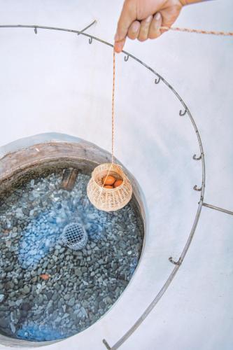 a person holding a wicker basket in a bucket of water at Minera Hot Springs Binh Chau in Binh Chau