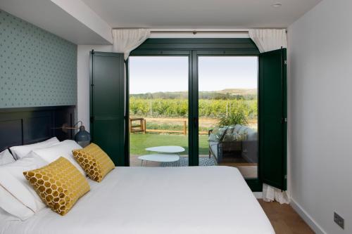 a bedroom with a bed and a large window at Villas Finca La Emperatriz in Baños de Rioja