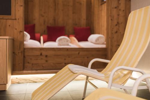 a rocking chair and a bed in a room at Park Hotel Villa Etschland in Plaus