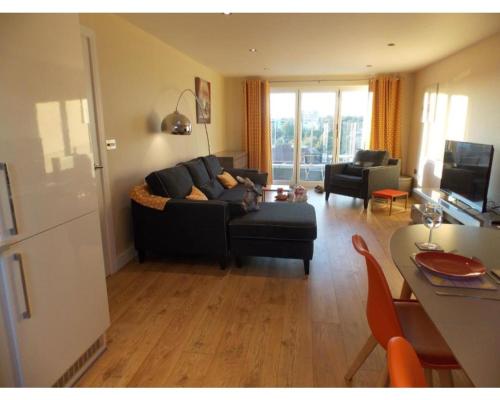 a living room with a couch and a table at Penthouse apartment in Basingstoke in Basingstoke