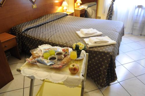 Una cama con una mesa con comida y bebidas. en Hotel Farini, en Roma
