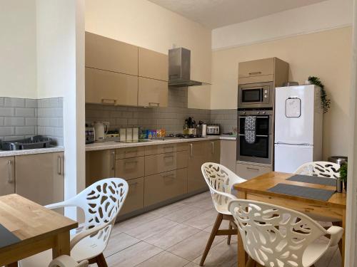 a kitchen with a table and chairs and a refrigerator at Be My Guest Liverpool in Liverpool