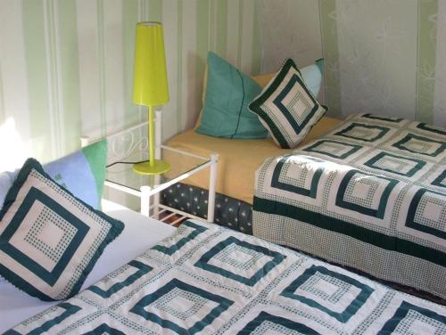 Zimmer mit 2 Betten und einem Tisch mit einer Lampe in der Unterkunft Pension Liebert in Weißenfels