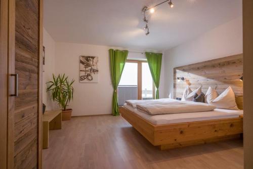 sypialnia z dużym łóżkiem z drewnianym zagłówkiem w obiekcie Appartements Linda w mieście Ellmau