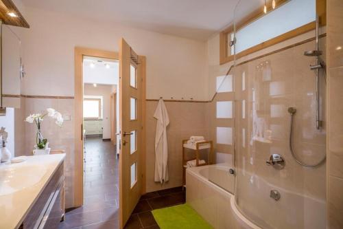 bagno con vasca, lavandino e doccia di Appartements Linda a Ellmau