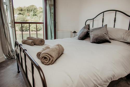 een groot wit bed met kussens erop bij Anchor Cottage Noss Mayo in Plymouth